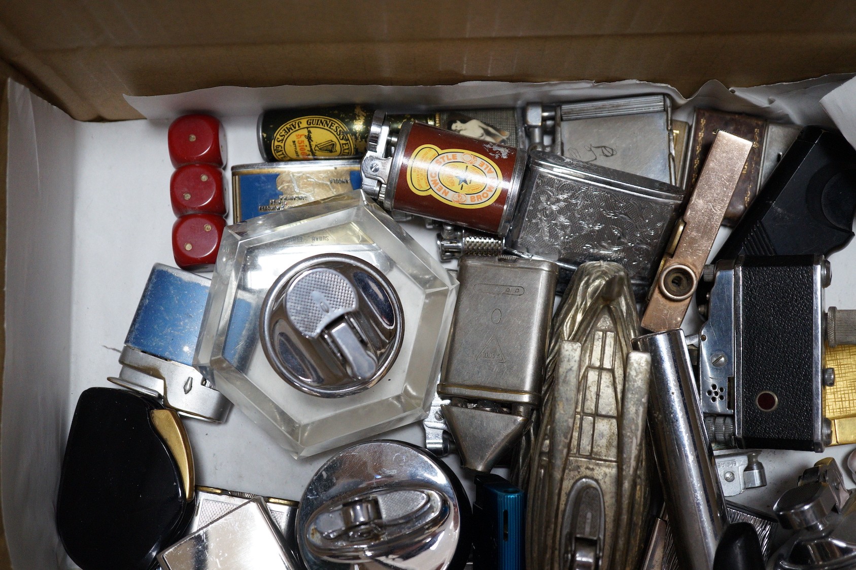 A collection of lighters including some novelty examples such as a percussion cup pistol, a KKW lighter camera, and a spy camera lighter